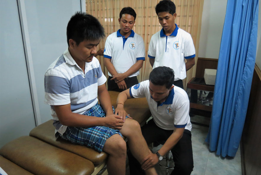 A physiotherapist examines a patient's leg