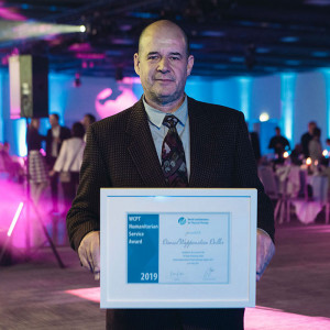 Daniel Wappenstein Deller holding his Humanitarian Service Award